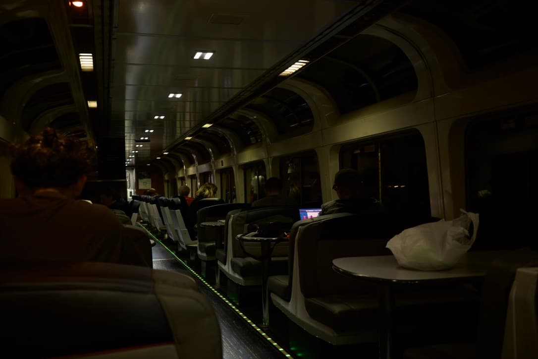 The dim interior of an Amtrak Southwest Chief train car at night